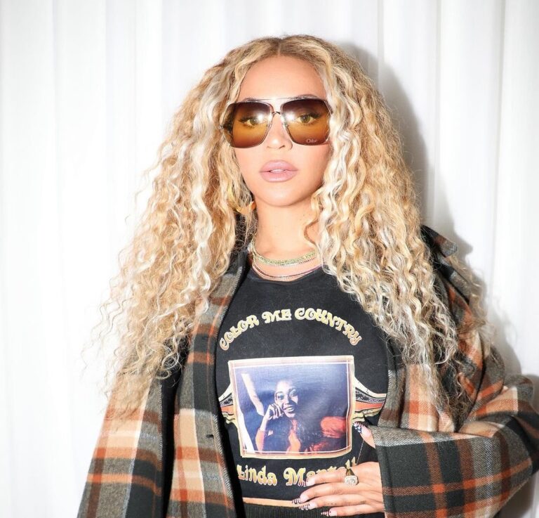 787878 Beyonce Promotes Cowboy Carter in a Chloe Oversized Plaid Cape A Linda Martell Color me Country Tee Black Prada Knit Shorts and a Ferragamo Bag